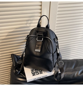 Close-up of black pebble leather backpack with silver zippers on modern urban decor