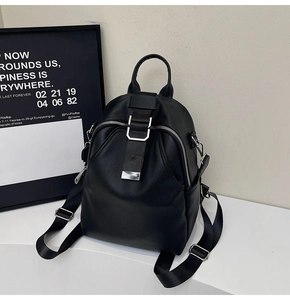 Close-up of black leather backpack detail with silver metal zipper and buckle
