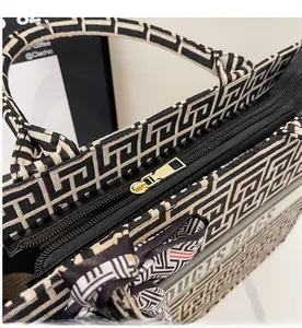 Detail of canvas tote bag showing smooth gold zipper and jacquard fabric texture