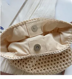Vue détaillée du sac tressé beige avec boucles magnétiques argentées et bandoulière