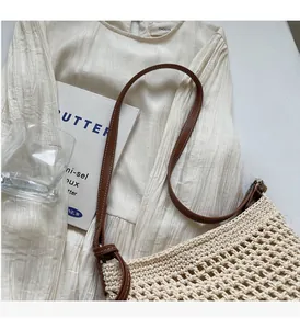 Détail du sac seau en maille ajourée en coton crème avec bandoulière en cuir brun