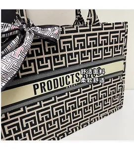 Detail of canvas tote bag showing black and white geometric jacquard and silk scarf handle