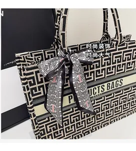 Close-up of black and white geometric canvas tote bag with silk bow and woven logo detail