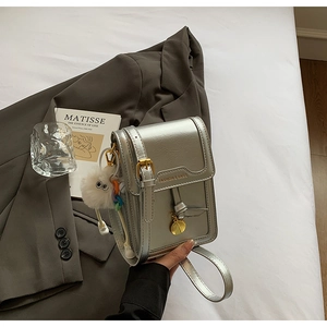 Silver metallic mini square bag featuring gold lettering and adjustable shoulder strap