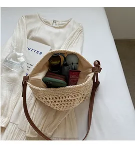 Détail du sac seau au crochet beige montrant la capacité intérieure et les objets