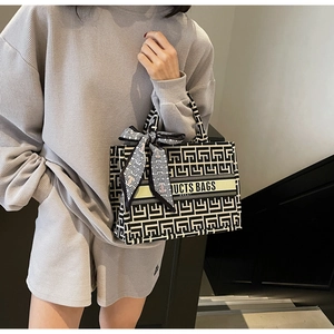 Detail of canvas tote bag with black and white geometric pattern and decorative scarf