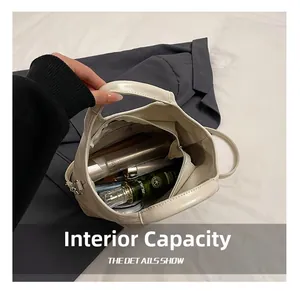 Macro view showing the internal capacity and zipper pocket of the cream white bucket bag