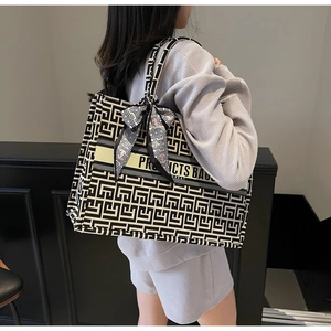 Detail showing high-capacity canvas tote bag with geometric pattern and silk scarf handle