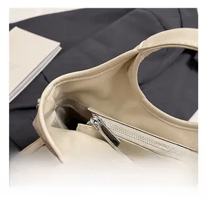 Macro detail of high-quality silver zipper and smooth cream leather texture on bucket bag