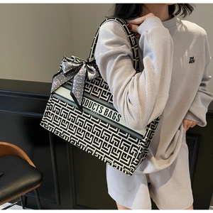 Detail of canvas tote bag with geometric pattern and decorative silk scarf handle