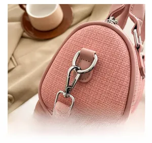 Close-up of pink woven pillow bag showing silver hardware connectors and leather details