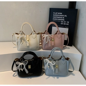 Detailed view of bucket bag showing soft lychee grain texture and gold turn-lock closure