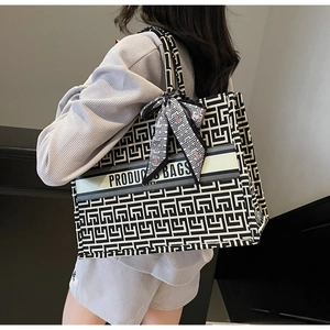 Detailed close-up of geometric pattern canvas tote bag with decorative silk handle scarf