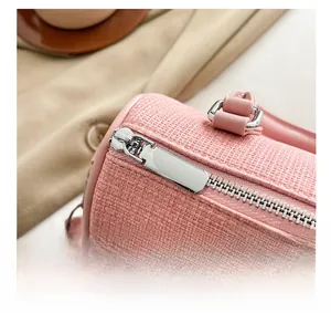 Detailed close-up of high-quality silver metal zipper on pink woven pillow bag