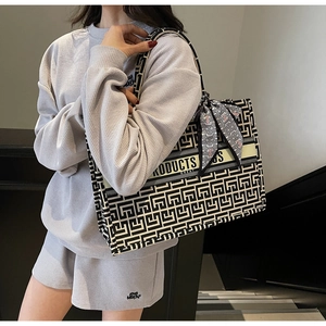 Detail of canvas tote bag with black and white geometric pattern and decorative scarf