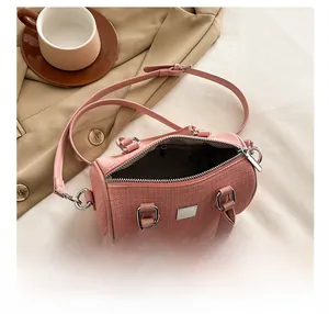 Detailed interior view of a pink tweed boston bag showing wave pattern lining and metal hardware