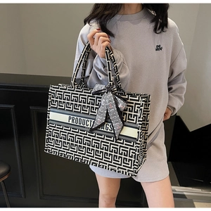 Detailed macro view of geometric jacquard canvas tote with decorative ribbon scarf