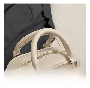 Dettaglio della borsa in pelle PU beige che mostra l'elegante ferramenta in metallo dorato