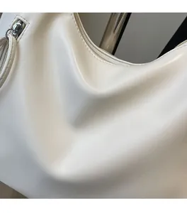 Detail shot of cream white leather bag showing high-quality zipper and soft pleated texture