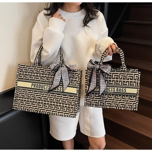Detailed comparison of large and small geometric canvas tote bags with silk ribbon accents