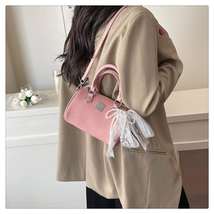 Detailed side view of pink Boston bag with woven texture and lace pearl bow on model