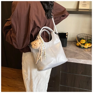 Light gray hobo shoulder bag with cute plush bear pendant and adjustable strap