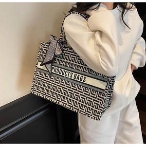 Detailed view of large canvas tote bag featuring geometric patterns and shoulder strap
