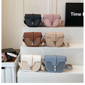 Detailed view of bicolor saddle bags with bohemian jacquard straps and metallic clasps