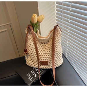 Détail d'un sac seau au crochet beige avec maille ajourée et bandoulière en cuir marron