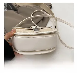 Detail showing the durable bottom structure and contrast strap of the saddle bag
