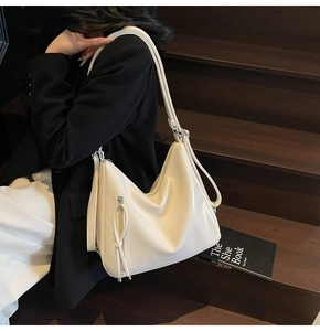 Detail view of large cream PU leather tote bag with stylish long zipper pull design