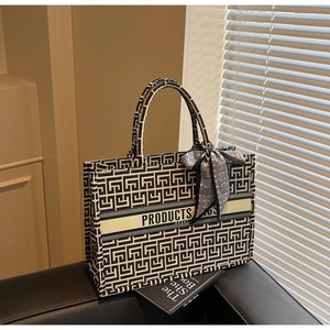 Macro detail of canvas tote bag featuring geometric patterns and stylish silk scarf accessory