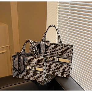 Detail of canvas tote bags with geometric patterns and decorative handles in two sizes