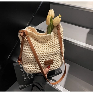 Gros plan détaillé d'un sac seau en maille ajourée avec lanières en cuir marron et logo