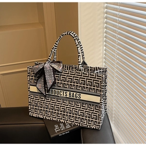 Detail of canvas tote bag featuring black and white geometric pattern and decorative scarf