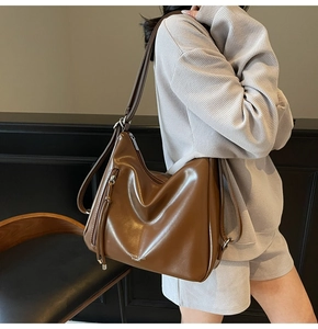 Detail of vintage brown faux leather shoulder bag with fashion text and silver zipper