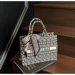Detail of canvas tote bag with geometric maze pattern and silk scarf on art book
