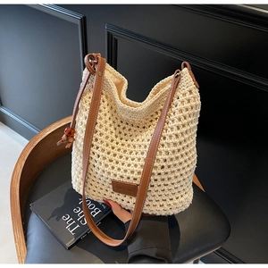 Gros plan sur le sac seau en tricot crème avec maille évidée et bandoulière en cuir
