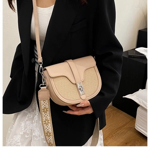 Detail of saddle bag with straw patchwork, beige leather, and ethnic woven shoulder strap