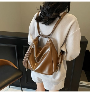 Detail of brown soft leather backpack with long tassel zipper and fashion embossed text