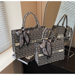 Close-up of geometric labyrinth jacquard canvas tote with decorative handle scarf