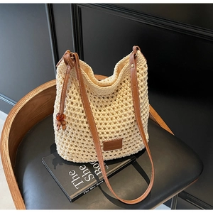 Détail du sac seau au crochet beige avec bandoulière en cuir brun et perles d'ambre