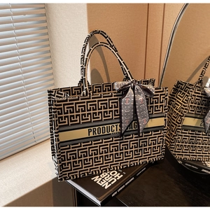 Detail of canvas tote bag with geometric pattern and floral scarf handle decoration