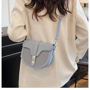 Close-up of light blue saddle bag with gray checkered texture and metal lock