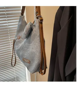 Detail of grey canvas tote bag with brown leather handles and a round hanging coin purse