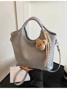 Light blue PU leather bucket bag with cute bear charm and woven strap detail
