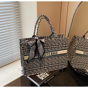 Close-up of geometric pattern canvas tote bag with silk scarf bow and book prop