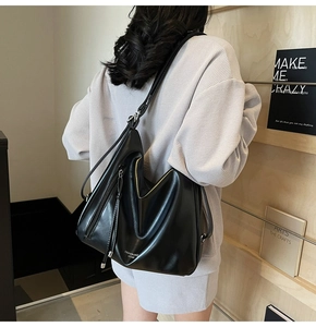 Detail of black soft leather tote bag with elegant side zipper and slim shoulder strap