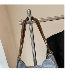 Close-up of casual blue denim tote bag with brown leather handles and metal zipper