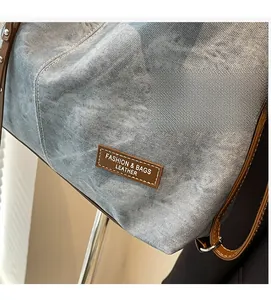 Detail of washed blue denim fabric with premium brown leather trim and fashion stitching